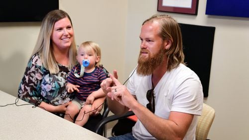 Michelle Adams with her husband, Randy Adams, and 16-month-old son, Max. Both father and son received cochlear implants to improve hearing. CONTRIBUTED BY JACK KEARSE / EMORY UNIVERSITY