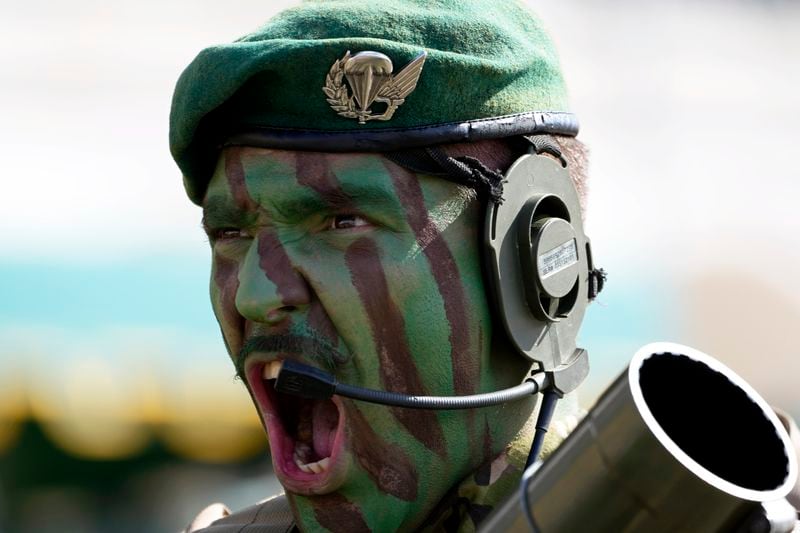A Portuguese paratrooper in combat gear yells while taking part in a military parade at Lisbon's Comercio square, Thursday, April 25, 2024, during celebrations of the fiftieth anniversary of the Carnation Revolution. The April 25, 1974 revolution carried out by the army restored democracy in Portugal after 48 years of a fascist dictatorship. (AP Photo/Armando Franca)