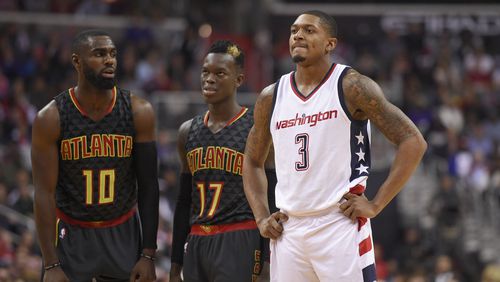 Washington Wizards guard Bradley Beal (3) looks on next to Atlanta Hawks guard Tim Hardaway Jr. (10) and guard Dennis Schroder (17), of Germany, during the second half in Game 2 of a first-round NBA basketball playoff series, Wednesday, April 19, 2017, in Washington. The Wizards won 109-101. (AP Photo/Nick Wass)