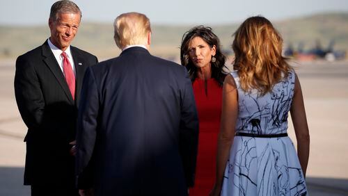 Sen. John Thune, R-South Dakota, and Gov. Kristi Noem greet President Donald Trump and first lady Melania Trump on Friday night.