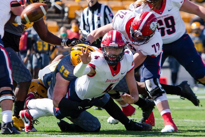 Kody Wilstead of Dixie State tries to get rid of the ball while being tackled. CHRISTINA MATACOTTA FOR THE ATLANTA JOURNAL-CONSTITUTION.