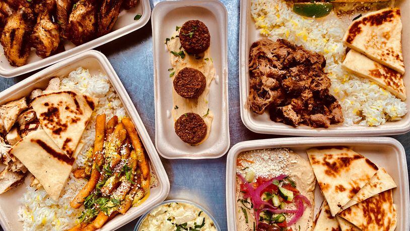 This takeout meal from Local Expedition includes (clockwise from upper left) chicken wings; falafel; pulled pork with Mexican corn; hummus; a side of potato salad; and smoked chicken with a side of “local” fries (topped with cilantro and lemon-garlic sauce, cotija cheese, parsley, and sumac). Plates come with rice and pita. Wendell Brock for The Atlanta Journal-Constitution