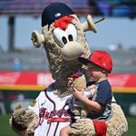 Blooper holds one of grandchild of Atlanta Braves manager Brian Snitker before the home opener spring training game against the Boston Red Sox at CoolToday Park, Sunday, Feb. 25, 2024, in North Port, Florida. (Hyosub Shin / Hyosub.Shin@ajc.com)