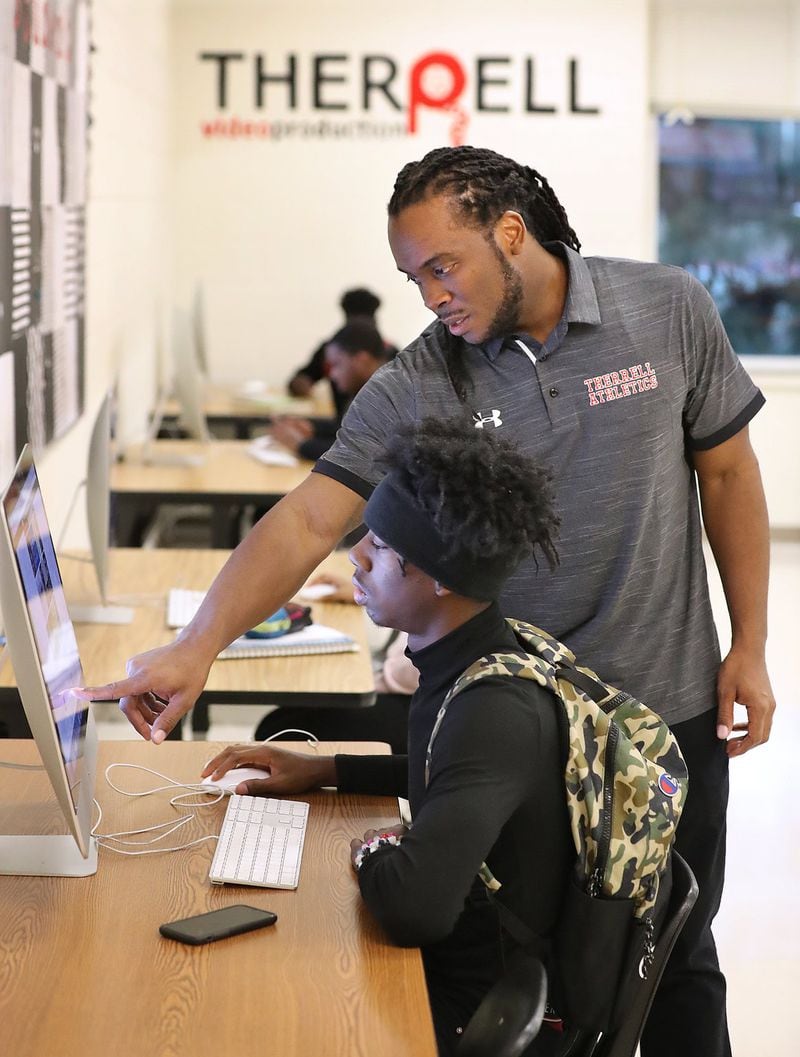 Play It Smart academic coach Matthew Hazel works with football player Deontre Morris while helping him input information into the online NCAA Clearinghouse, a requirement to become eligible to play college sports, on Dec. 16, 2019, in Atlanta.. The group was meets after school at Therrell High School. CURTIS COMPTON/CCOMPTON@AJC.COM