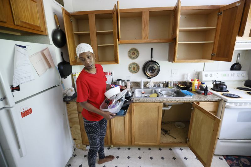 Pavilion Place tenant Danielle Russell washes her cookware to keep it clean from vermin that infested her southwest Atlanta apartment. This summer, she stored it inside plastic bags in the living room as she waited for an exterminator to complete deep treatments, but he failed to arrive for a second visit. (Miguel Martinez/miguel.martinezjimenez@ajc.com)