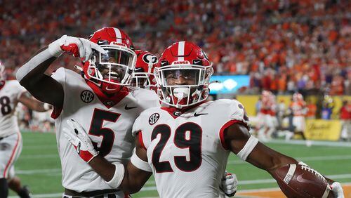 Georgia defensive back Christopher Smith (right) strikes a pose alongside teammate Kelee Ringo after intercepting a pass against Clemson and returning it 74 yards for a touchdown in the second quarter of what ended as a 10-3 win over the No. 3-ranked Tigers in the Dukes Mayo Classic in Charlotte on Sept. 4, 2021. (Photo by Curtis Compton/ccompton@ajc.com)