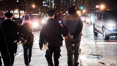 FILE -- Police lead two cuffed people down a street on a night of protests over a grand jury's declining to indict an officer in connection with the July 2014 death of Eric Garner during his arrest, in New York, Dec. 3, 2014. Questions on use of force in a 2013 Justice Department survey of police departments yielded nearly useless data since the way force incidents were recorded or categorized, varied so widely. (Robert Stolarik/The New York Times)