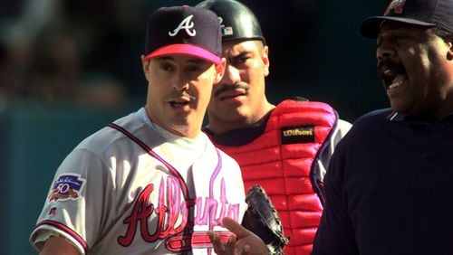 With catcher Eddie Perez listening in (background), Braves starting pitcher Greg Maddux argues a call with umpire Eric Gregg (right) during NLCS Game 5 Oct. 12, 1997, against the Florida Marlins in Miami. (W. A. Bridges, Jr./AJC)