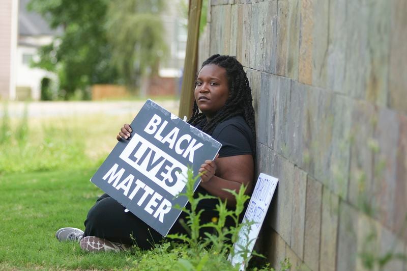 Britt Jones-Chukura pictured at her home in Atlanta this month. Jones-Chukura, the founder of Justice for Georgia is holding signs she used during protests and rallies she spearheaded in 2020 and 2021. (Natrice Miller / natrice.miller@ajc.com)