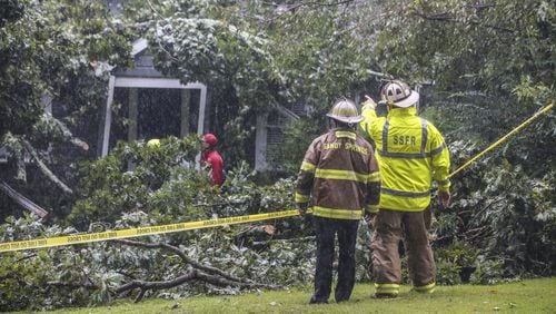 A tree falling on a home in Sandy Springs killed a man Monday. In Atlanta on Tuesday, four people were trapped in their homes by falling trees. JOHN SPINK/JSPINK@AJC.COM