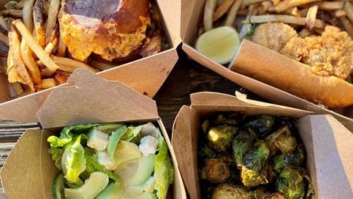 Takeout from Biggerstaff includes (clockwise from top left) the house burger with pimento cheese and bacon; the loaded seafood po’boy; crispy Brussels sprouts; and a gem salad. Wendell Brock for The Atlanta Journal-Constitution