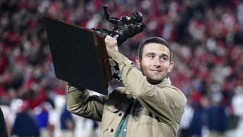 Former Georgia and current Los Angeles Rams quarterback Stetson Bennett holds the Burlsworth Trophy he earned for being college football's top walk-on during the first half of an NCAA college football game between Mississippi and Georgia, Saturday, Nov. 11, 2023, in Athens, Ga. (AP Photo/John Bazemore)