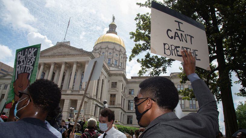 Marchers hold up signs in front of the State Capitol during a march in honor of George Floyd’s Funeral Thursday, June 4, 2020. STEVE SCHAEFER FOR THE ATLANTA JOURNAL-CONSTITUTION