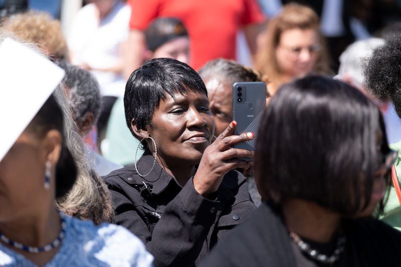 An attendee records a presentation during the unveiling ceremony for a statue of the Rev. Martin Luther King Jr. in Rodney Cook Sr. Peace Park in Atlanta on Saturday, April 1, 2023. (Ben Gray / Ben@BenGray.com)