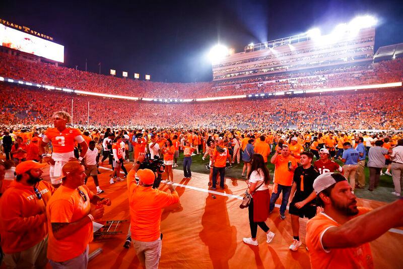 Fans rush the field after an NCAA college football game between Tennessee and Alabama Saturday, Oct. 15, 2022, in Knoxville, Tenn. Tennessee won 52-49. (AP Photo/Wade Payne)