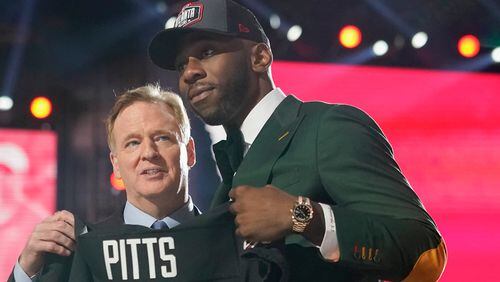 Florida tight end Kyle Pitts (right) holds a Falcons jersey with NFL Commissioner Roger Goodell after he was chosen by the Atlanta Falcons with the fourth pick in the NFL football draft, Thursday, April 29, 2021, in Cleveland. (Tony Dejak/AP)