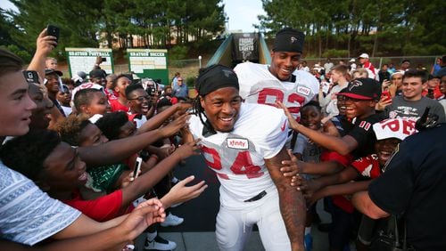 Fans reach out for Atlanta Falcons running back Devonta Freeman (24) and tight end Joshua Perkins (82) during the ninth annual “Kia Motors Friday Night Lights” at Grayson High School, Friday, August 5, 2016, in Loganville, Ga. BRANDEN CAMP/SPECIAL