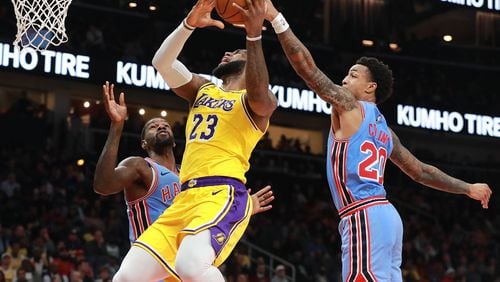 Hawks forward John Collins blocks a shot by the  Lakers’ LeBron James during the second half of a Feb. 12 game in Atlanta.