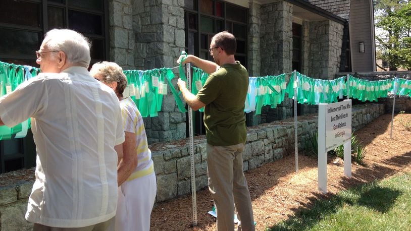 Following services Sunday at North Decatur Presbyterian Church, congregants hung green ribbons, one for each of the Charleston victims, on an installation usually dedicated to Georgia victims of gun violence.(Ariel Hart, ahart@ajc.com)
