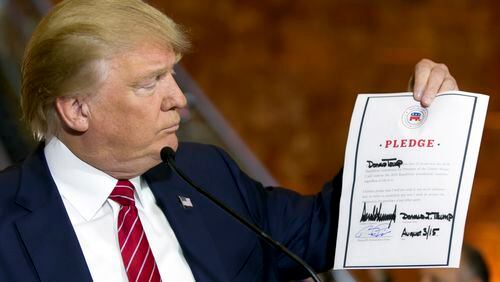 Republican presidential candidate Donald Trump looks at a signed pledge during a news conference in Trump Tower in New York.