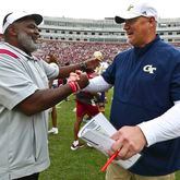 Florida State associate head coach/defensive tackles coach Odell Haggins, left, shakes hands with Georgia Tech quarterbacks coach Chris Weinke after of an NCAA college football game Saturday, Oct. 29, 2022, in Tallahassee, Fla. Weinke was the Heisman Trophy-winning quarterback for Florida State in 2000. Florida State won 41-16. (AP Photo/Phil Sears)