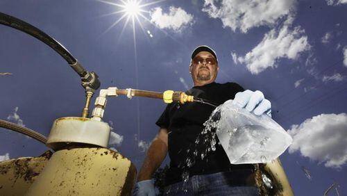 Dan Day, a water lab technician with the City of Dayton, takes a sample from one of 200 monitoring wells used to check on the quality of water in the Great Miami Buried Valley Aquifer and test for any contaminants on a regular basis. CHRIS STEWART / STAFF