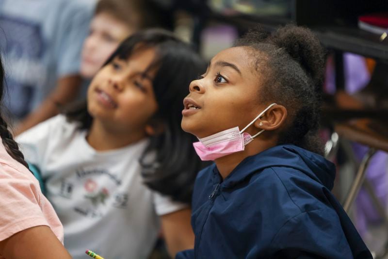 First grade students Destinee Walker, right, and Camila Sandoval listen to their teacher Chantel Jones (not pictured) teach students the “Science of Reading,” a phonics-based approach, at Dunleith Elementary School, Friday, February 3, 2023, in Marietta, Ga.. Jason Getz / Jason.Getz@ajc.com)