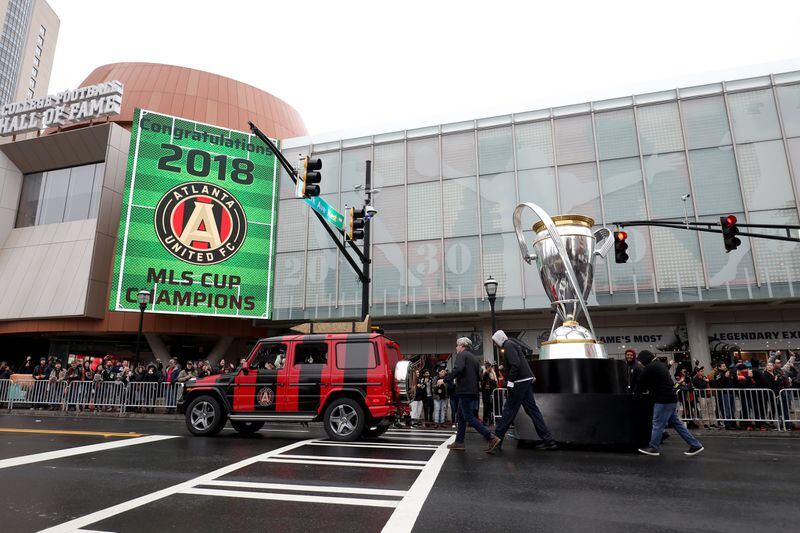 The golden spike and an oversized rendition of the MLS Cup is paraded past the College Football Hall of Fame along Marietta Street during the Atlanta United MLS Cup victory parade Monday, December 10, 2018, in Atlanta. (JASON GETZ/SPECIAL TO THE AJC)