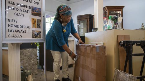 Anita Jordan, owner of Benu Glass Creations, packs up her belongings as she prepares to move out of the building she's been renting in Stone Mountain Village. (ALYSSA POINTER / ALYSSA.POINTER@AJC.COM)
