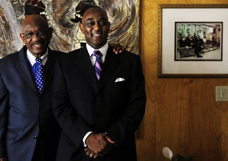 Herman J. Russell and his son Michael Russell at their Collier Heights home in 2008. Herman built the home in the early 1960s and it quickly became a gathering place for Martin Luther King Jr. and other black leaders in a time when they still couldn’t use segregated facilities downtown. The photo behind them shows Martin Luther King Jr. and Andrew Young among others meeting in the room they are posed. ELISSA EUBANKS / AJC FILE PHOTO