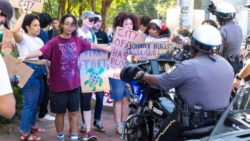 Protestors against Atlanta’s planned public safety training center, known by some as “Cop City,” gather at Fulton County Courthouse in Atlanta on Monday, August 14, 2023, as Fulton prosecutors present a their election interference case against former President Donald Trump and others to a grand. (Arvin Temkar / arvin.temkar@ajc.com)