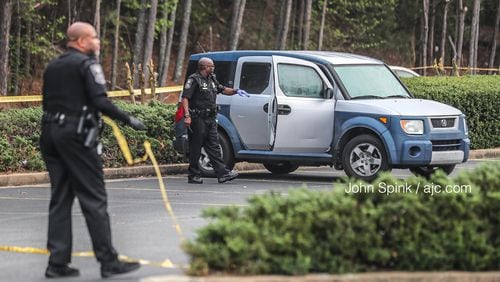 DeKalb County police investigate a fatal shooting Wednesday morning in the parking lot of the Salem Crossing plaza on Panola Road.