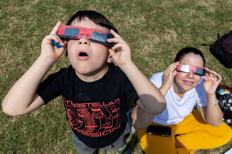 Mateo, 5, and Andrea Moyano of Buford watch the solar eclipse at Gwinnett Georgia College in Lawrenceville.