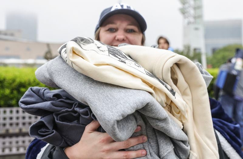 Tessa Hoskins holds a pile of Taylor Swift merchandise outside of Mercedes Benz Stadium on Thursday, April 27, 2023. Hoskins says she arrived in Atlanta from Pulaski, Ga. at midnight and got in line at 5 a.m. to wait in line. (Natrice Miller/natrice.miller@ajc.com)