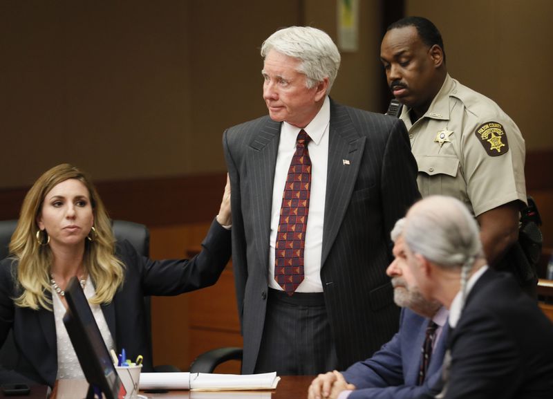 Standing amid his attorneys, Tex McIver is handcuffed and taken into custody after the verdict. The jury found McIver guilty on four of five charges in the death of his wife. (Bob Andres/AJC)
