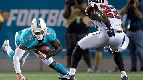 Miami Dolphins wide receiver DeVante Parker loses his footing as he tries to get away from Falcons strong safety Keanu Neal in the first half of a preseason game Thursday night in Orlando. (AP photo)