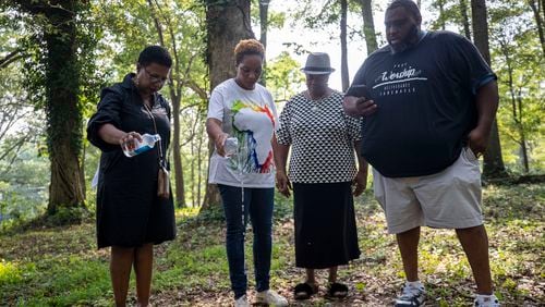 07/26/2021 — Newnan, Georgia — Peggy King Jorde (from left), Ayisat Idris-Hosch, Lillie Smith and Pastor Render Godfrey say a prayer and bless the ground at Farmer Street Cemetery in Newnan, Monday, July 26, 2021. (Alyssa Pointer/Atlanta Journal-Constitution)