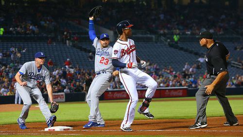 Atlanta Braves' B.J. Upton bunts for a single, reaching first safely past Los Angeles Dodgers' Adrian Gonzalez during the fifth inning on Monday, Aug. 11, 2014, at Turner Field in Atlanta, Ga. (Curtis Compton/Atlanta Journal-Constitution/MCT)