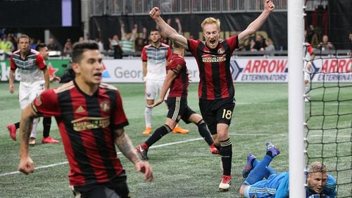Atlanta United midfielder Jeff Larentowiz (center) and teammates react as a shot by teammate Hector Villalba (far left) gets past D.C. United goalkeeper David Ousted for a 3-0 lead during the second half in a MLS soccer match on Sunday, March 11, 2018, in Atlanta. Atlanta United won the game 3-1.    Curtis Compton/ccompton@ajc.com