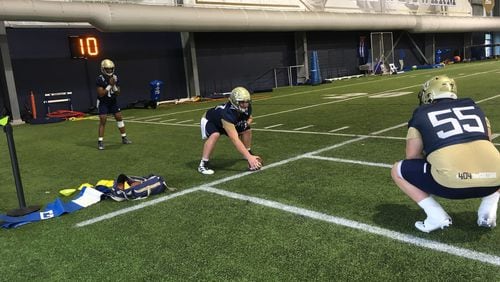 Georgia Tech offensive lineman Mikey Minihan works on his shotgun snaps with quarterback James Graham under the eye of center Kenny Cooper (No. 55) at the Yellow Jackets' first spring practice, March 3, 2020, at the Brock Football Practice Facility. (AJC photo by Ken Sugiura)