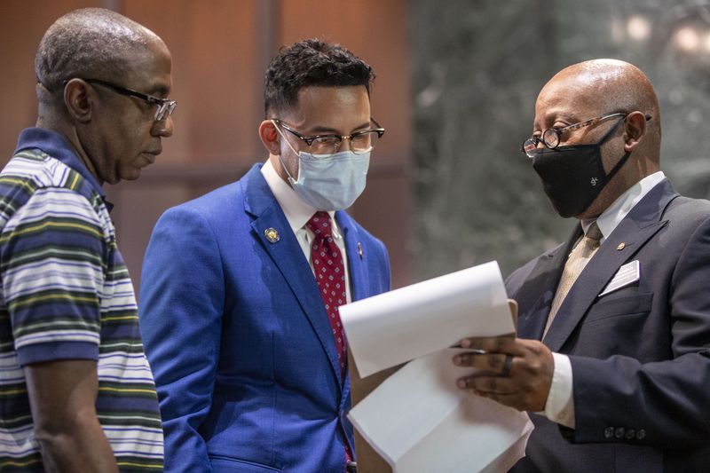 Atlanta City Councilman Antonio Brown, center, prepares to fill out paperwork that will allow him to qualify for the Nov. 2 mayoral election at Atlanta City Hall on Friday. (Alyssa Pointer/Atlanta Journal Constitution)