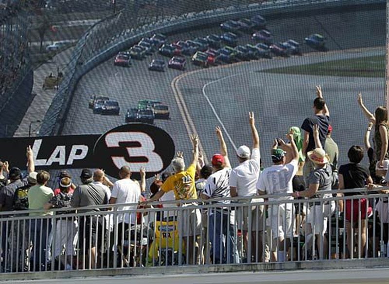 NASCAR fans hold up three fingers on the third lap of the Daytona 500 auto race as a tribute to Dale Earnhardt while watching a large television screen at Daytona International Speedway.