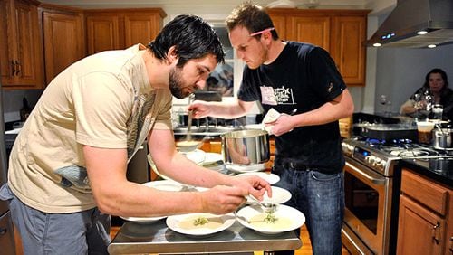 Ryan Hidinger (left) and his sous-chef Ben Barth serve fennel soup with apple relish at the Jan. 31 seating of Prelude to Staplehouse, an underground supper club.