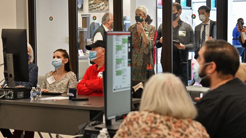 Democratic and Republican Party watchers (background) observe as members of the adjudication review panel examine scanned ballots at Gwinnett County Election headquarters in Lawrenceville on Friday. (Hyosub Shin / Hyosub.Shin@ajc.com)