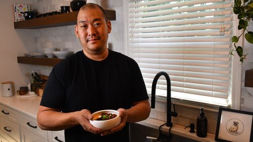 230320 Marietta, Ga: Chef Brian So in his Marietta home kitchen with one of his personal favorite meals, Dan Juk (Korean Congee) made his way, with soft boiled egg, scallions, crispy chicken skins, kosher salt, black pepper and spicy chili crisps. Photos for use with story on chef Brian So and his Dak Juk (Korean Congee) for AJC series At Home AAJC040623ATHOMECHEFBRIANSO Photo taken March 20, 2023 at the home of chef Brian So. (CHRIS HUNT FOR THE ATLANTA JOURNAL-CONSTITUTION)