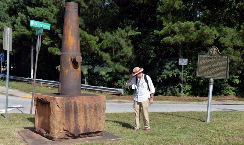 At the intersection of Wilkinson Drive and Glenwood Avenue, a cannon is placed as a marker memorializing the death of Confederate Gen. W.H.T. Walker. Standing between the cannon and a sign marking the death is Atlanta Journal-Constitution staff writer Mark Davis, retracing steps of a march ahead of a fateful battle. Walker was near that spot when a Union sharpshooter, hiding in the woods at Sugar Creek, took aim and fired, killing the general. KENT D. JOHNSON / KDJOHNSON@AJC.COM