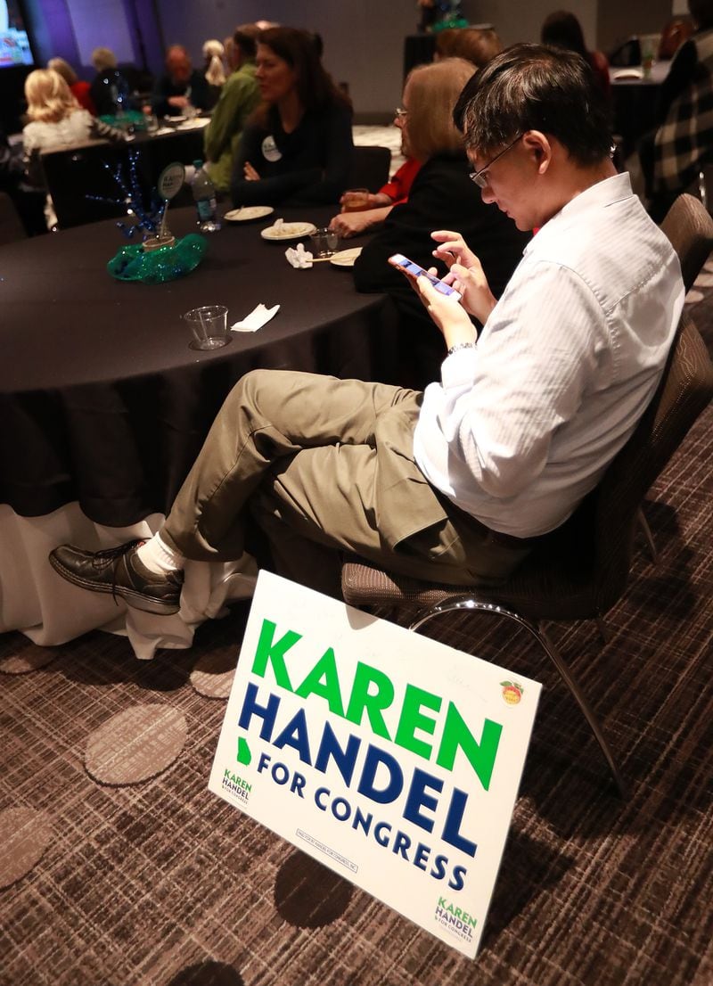 In this AJC file photo, Karen Handel supporter Fang Zhou tracks returns at her election watch party on Tuesday, Nov. 6, 2018, in Atlanta.  