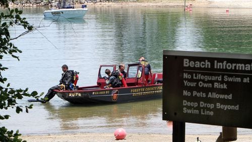 Forsyth County divers prepare to search the swimming area of Buford Dam Park on Lake Lanier on Sunday. A man disappeared there after a church baptism that was conducted in the lake.
