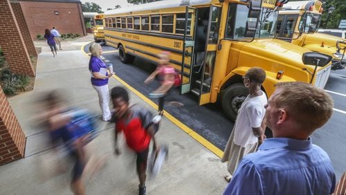 Dr. Derek Schroll (right) watches students arrive for their first day of school at Coleman Middle School at 3057 Main Street in Duluth. Coleman Middle is one of the smaller schools in the Gwinnett County School District, with 777 students this year.
