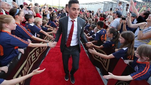 Atlanta United midfielder Miguel Almiron high fives fans during the team arrival at Mercedes-Benz Stadium to play Sporting Kansas City in a MLS soccer match on Wednesday, May 9, 2018, in Atlanta.  Curtis Compton/ccompton@ajc.com